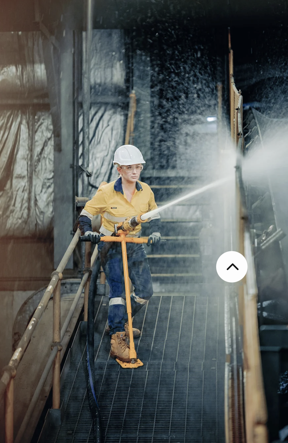 Worker in hi-vis using the Safe-T-Grip to direct a high-pressure hose on industrial grating
